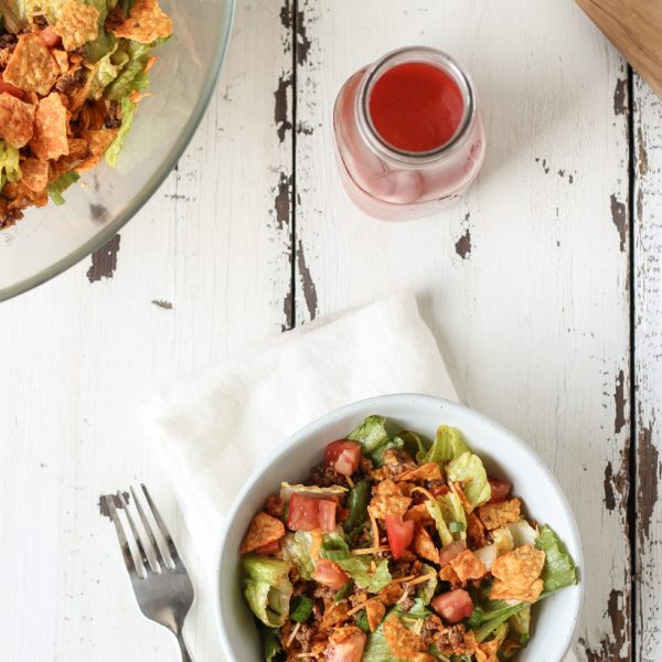 A delicious taco salad made with fresh produce, flavorful seasoned beef, crunchy Dorito chips and a special tangy dressing! This party favorite is fast, fresh, delicious, and always a crowd-pleaser!