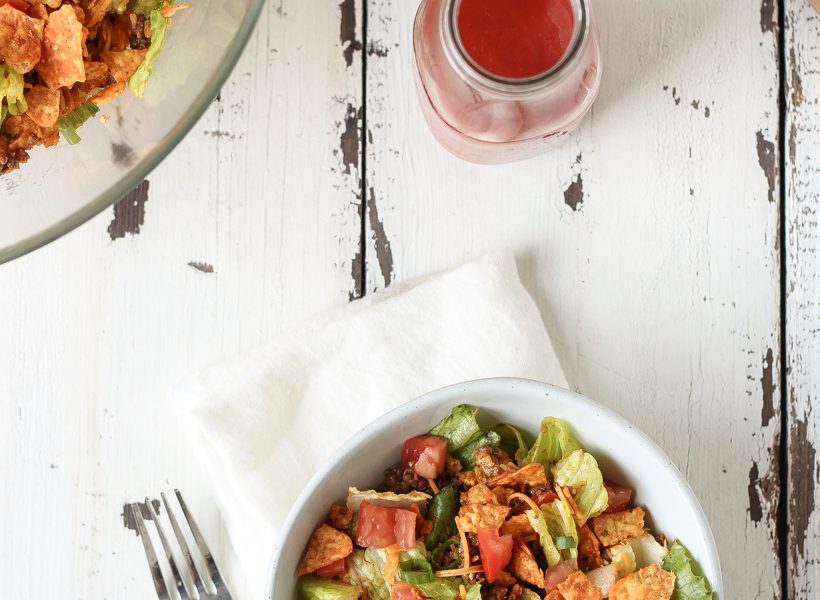 A delicious taco salad made with fresh produce, flavorful seasoned beef, crunchy Dorito chips and a special tangy dressing! This party favorite is fast, fresh, delicious, and always a crowd-pleaser!