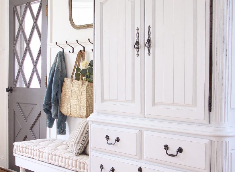 A dark and dated armoire gets a makeover with creamy white paint and beautifully distressed details. Find out how to easily antique furniture with this tutorial!