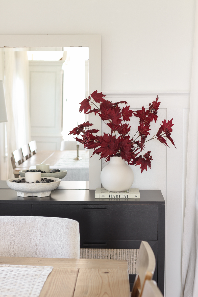 Home blogger and interior decorator Liz Fourez shares a beautiful fall vignette in her dining room featuring deep red fall branches and a new furniture find that has a high-end look without the high-end price