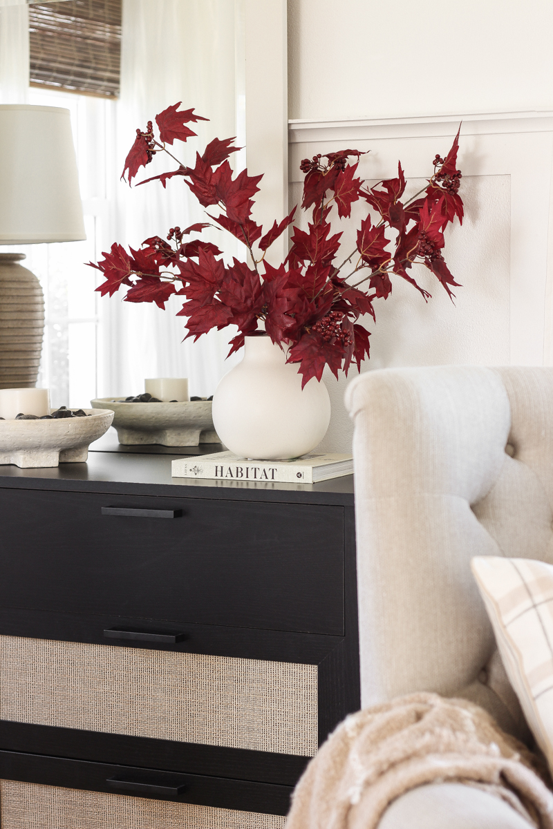 Home blogger and interior decorator Liz Fourez shares a beautiful fall vignette in her dining room featuring deep red fall branches and a new furniture find that has a high-end look without the high-end price