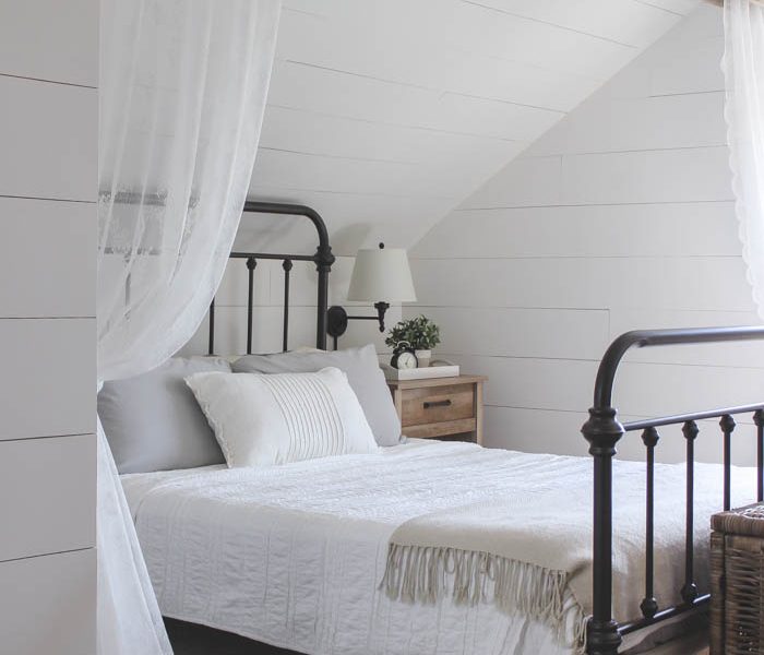 This cozy sleeping nook was created by adding a faux wood beam and lace curtains over the bed, and the results are amazing! See how to do this project in your home at LoveGrowsWild.com